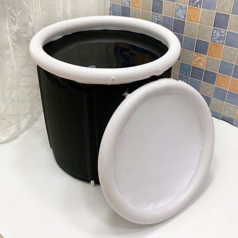Black and white collapsible bucket with lid on a tiled bathroom floor.